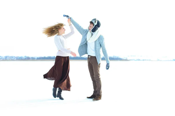 Mujer vistiendo falda marrón y suéter bailando con el hombre en fondo de nieve . — Foto de Stock