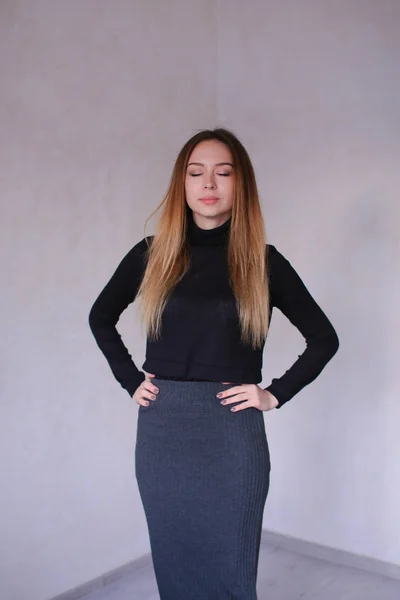 Jonge vrouw dragen zwarte blouse en grijs shirt permanent in monofone achtergrond. — Stockfoto