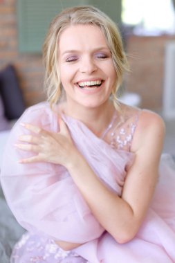 Oturma odasında ve gülümseyen mutlu sevimli sarı gelin.