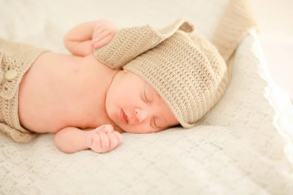 Ładne kaukaski noworodka snu oraz noszenie ubrania szydełkowe. — Zdjęcie stockowe