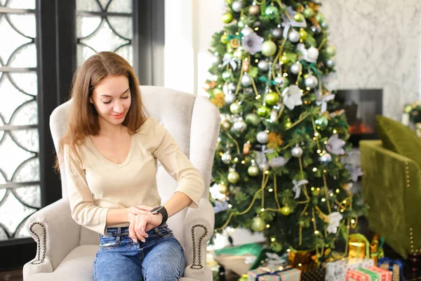 Novia prueba smartwatch Año Nuevo presente en habitación acogedora . — Foto de Stock