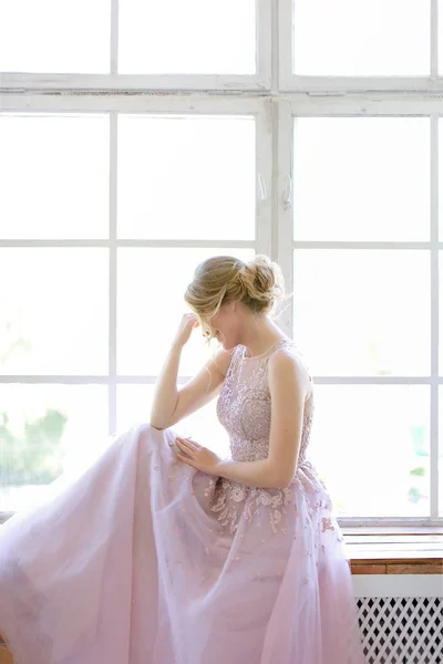 Loira noiva caucasiana de pé perto da janela e sonhando . — Fotografia de Stock