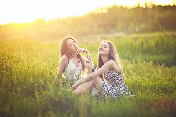 Otların arasında güneş ışınları üzerinde oturan ve konuşan genç kız.