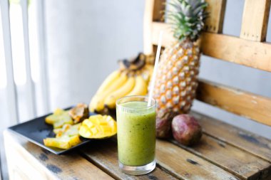 Nefis sarı muz, carambola çam apple ve ahşap sandalye, Yeşil taze kivi suyu mango ile.