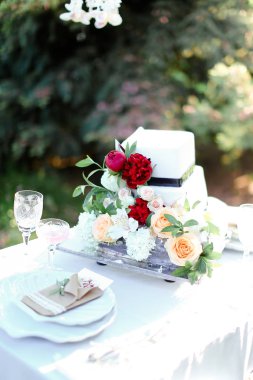 Beyaz lezzetli düğün pastası ile kırmızı şakayık.