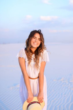 Beyaz elbise s giyen şapka tutmak mutlu beyaz kadın kişi
