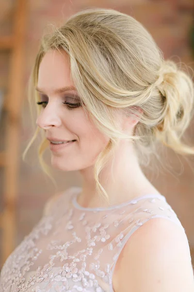 Closeup portrait of beautiful blonde bride with tender hairdo.