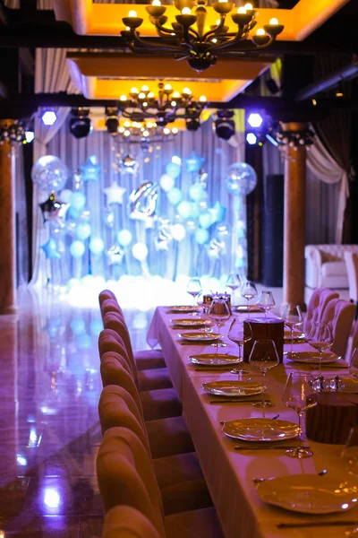 Mesa servida con globos azules en escena iluminada en el restaurante . — Foto de Stock