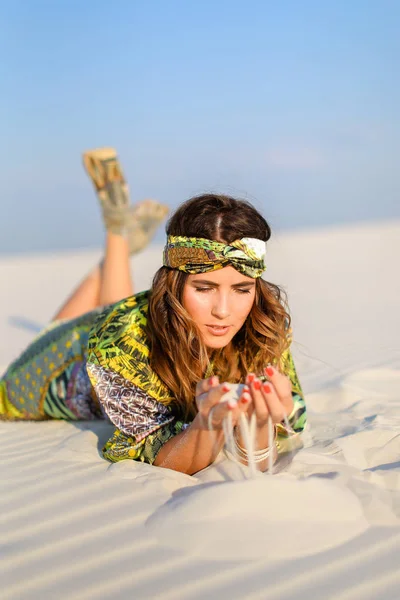 Genç model giyen yeşil plaj elbise beyaz kum üzerinde yalan fotoğraf.