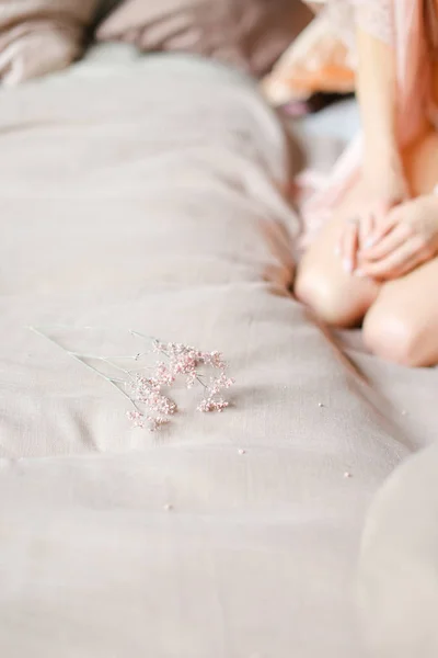 Jovem mulher sentada na cama e vestindo roupas íntimas . — Fotografia de Stock