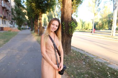 Elbise ayakta dışında fotoğraf makinesi ile giyen genç kadın turist.