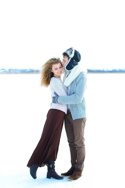 Mulher abraçando menino usando chapéu de inverno e mitenes no fundo de inverno . — Fotografia de Stock