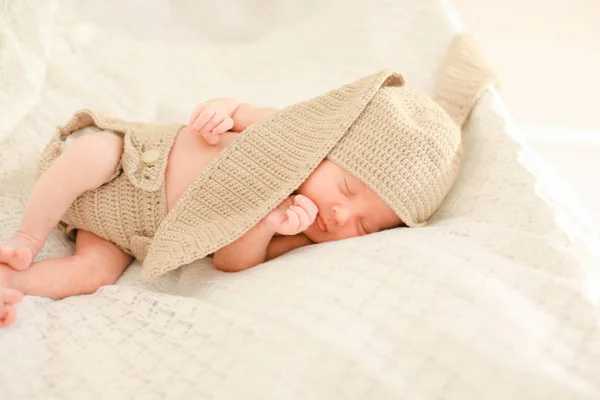 Kaukasisches Neugeborenes schläft und trägt gehäkelte Kleidung. — Stockfoto