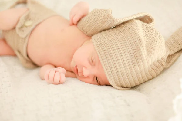 Pretty newborn baby sleeping and wearing crocheted clothes. — Stock Photo, Image