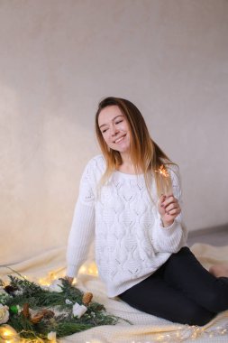 Bengal ışık parlayan sarı çelenk ve yeşil çelenk yakınında oturan genç Sevimli Kadın.