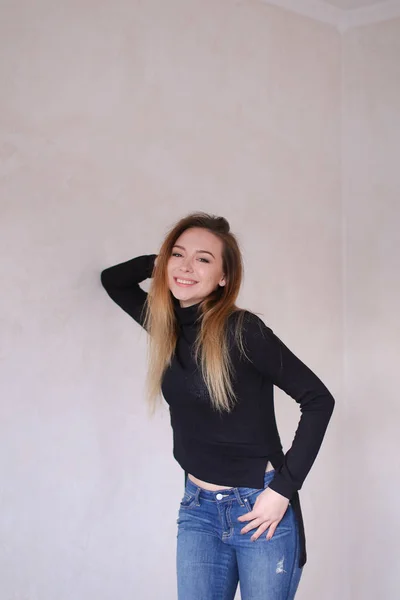 Young caucasian woman wearing black blouse standing near wall. — Stock Photo, Image