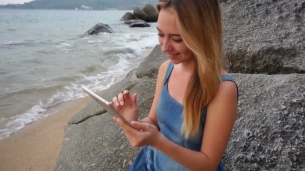 Slow motion stylist flicka med tablett titta på foton på seaside. — Stockvideo