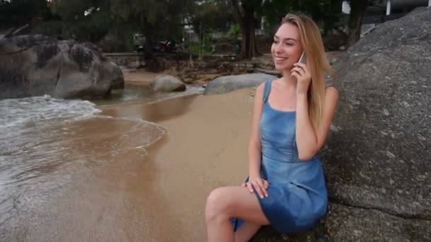 슬로우 모션 모델 여자 바다 근처 스마트폰에 말하기. — 비디오