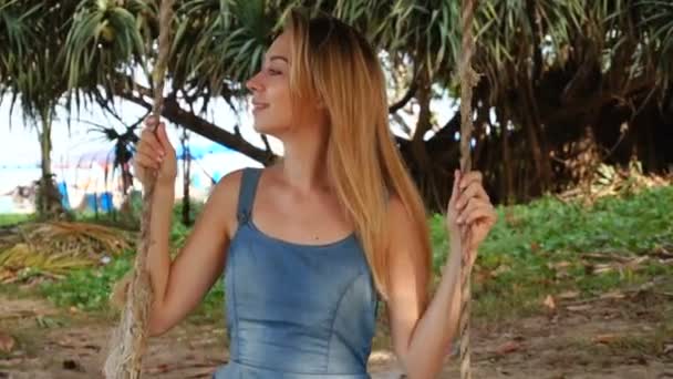 Slow motion wet student dame op vakantie swingen in tuin. — Stockvideo