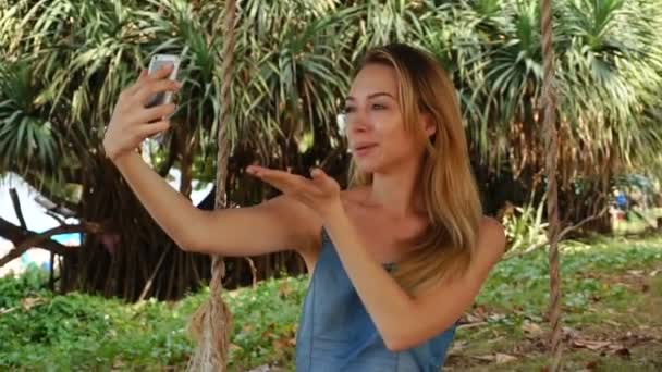 Slow motion zanger vrouw met smartphone te nemen van selfies buitenshuis — Stockvideo