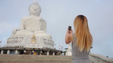 Fotoğrafların Buda'nın Tayland s heykel için akıllı telefon kullanan yavaş hareket gazeteci kız.