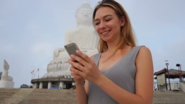 Slow motion grafik tasarımcı kadın manifatura Buda s heykel Tayland yakınındaki Smartphone.