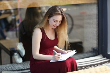 Yazılı defter Üniversitesi'nde, tablo smartphone olarak genç beyaz öğrenci.