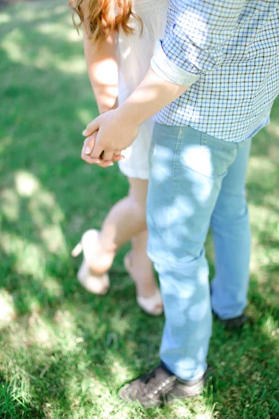 Closeup cara e menina de mãos dadas no fundo grama . — Fotografia de Stock