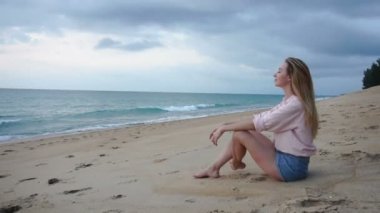 Ağır çekim çevirmen genç kadın rahatlatıcı deniz kum Plajı'nda