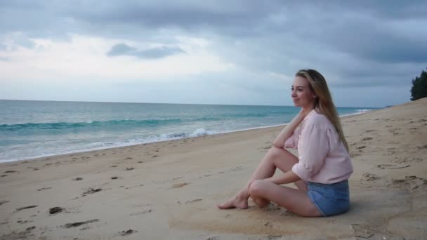動きが遅い作家の女の子が海辺でインスピレーションを求めてください。. — ストック動画