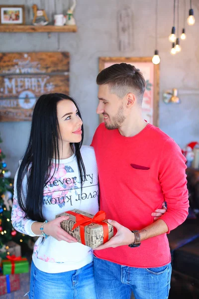 Mannen gifting kvinna närvarande inredda rummet, firar jul. — Stockfoto