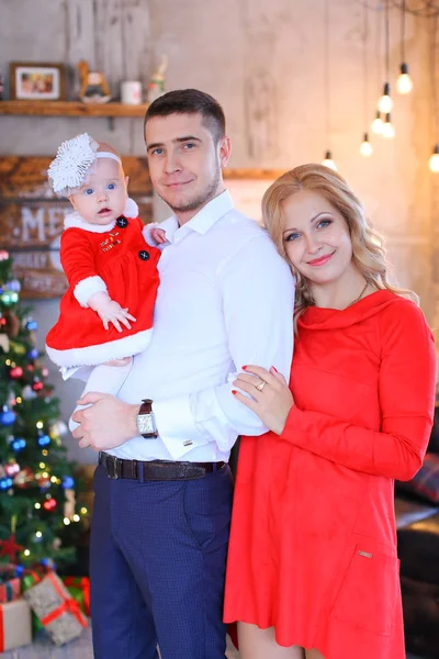 Jovem mulher bonita e homem de pé com bebê feminino perto da árvore de Natal . — Fotografia de Stock