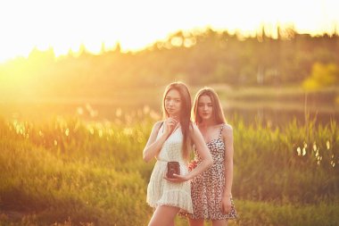 Otların arasında güneş ışınları üzerinde duran ve konuşan genç kız.