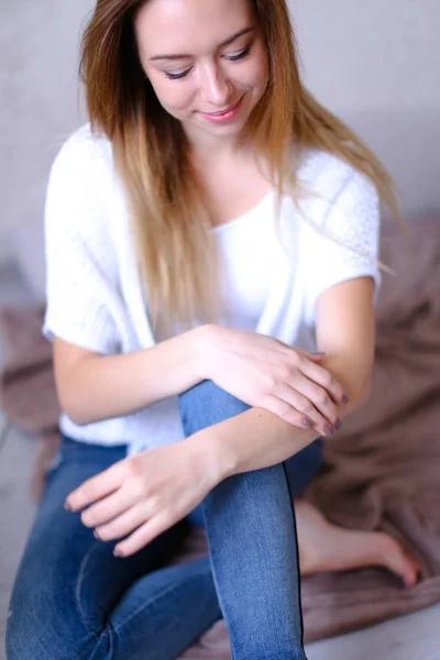 Junge blonde Frau trägt weißes T-Shirt und Jeans. — Stockfoto