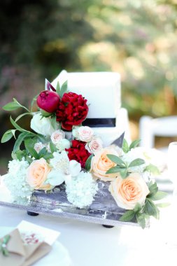 Beyaz güzel düğün pastası ile kırmızı şakayık.