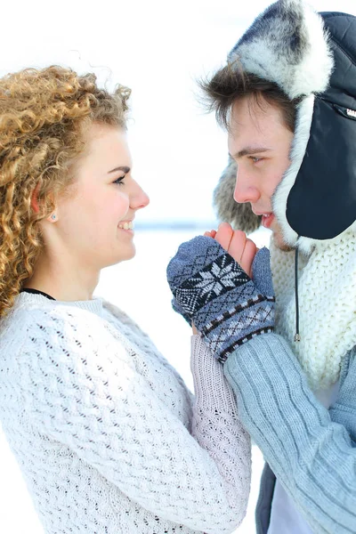 Mulher branca e homem de chapéu de inverno e mitenes de pé em fundo de inverno branco . — Fotografia de Stock