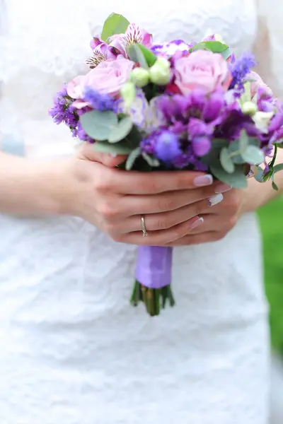 Closeup agradável vioelt buquê de flores em mãos de noiva . — Fotografia de Stock
