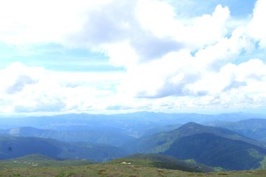 Mavi ve yeşil Karpat Dağları ile arka planda bulutlar.