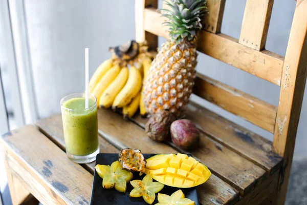 Muz, carambola çam apple ve ahşap sandalye, Yeşil taze kivi suyu mango ile.