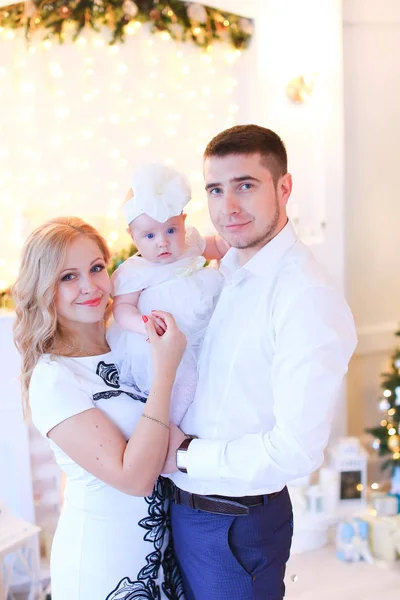Uśmiechnięta Blondynka matka i ojciec, utrzymując małe dziecko kobieta w urządzony pokój na Boże Narodzenie. — Zdjęcie stockowe