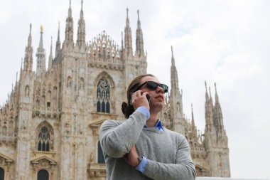 Beyaz işadamı smartphone Milan Katedrali, İtalya tarafından konuşma.