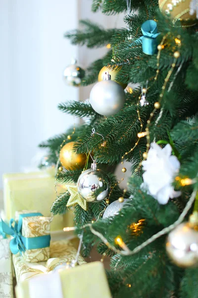 Close-up van gedecoreerde kerstboom met gele slingers en geschenken. — Stockfoto