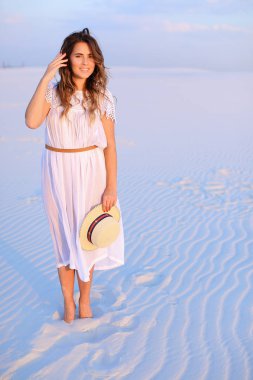 Elbise ve san üzerinde duran şapka, tutmak genç mutlu kadın