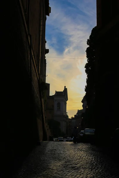 Atardecer calle estrecha con adoquines en las nubes del atardecer . — Foto de Stock
