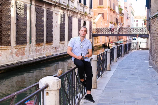 Joven turista sentado en la barandilla en Venecia, Italia . — Foto de Stock