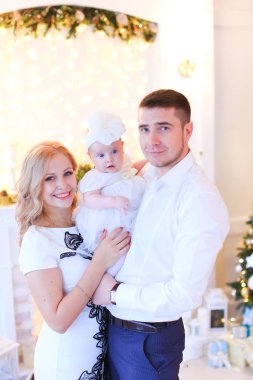 Annem ve babam küçük kadın bebek Noel için dekore edilmiş Oda tutmak gülümseyen.