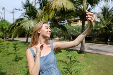Genç güzel kadın selfie smartphone ile avuç içi arka plan yapma.