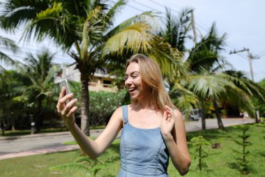 Genç gülümseyen kadın selfie smartphone ile avuç içi arka plan yapma.