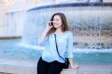 Genç işkadını yanında smartphone Trevi Çeşmesi arka planda konuşuyor.