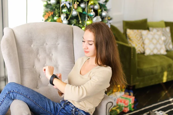Vriendin testen smartwatch Nieuwjaar aanwezig in gezellige kamer. — Stockfoto